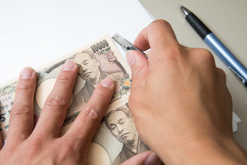 1万円札と同じ大きさに紙をカットする手作業