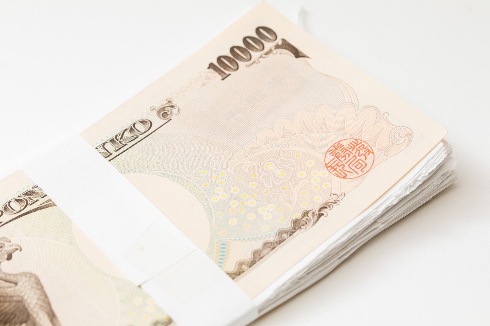 茶色の背景に置かれた一万円札風の札束のパロディグッズ
