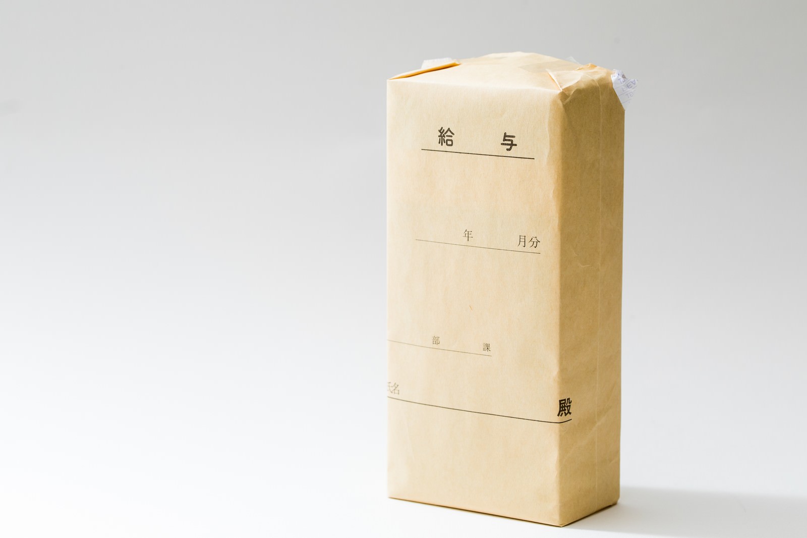 白い背景に立てられた茶色の給料袋