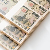 白い背景に積み重ねた偽札の札束の写真