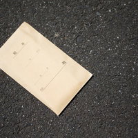 アスファルト道路に落ちた給与袋トラップ：金銭喪失と経済的リスクの写真
