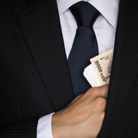 懐から紙幣をチラつかせるスーツの男の写真