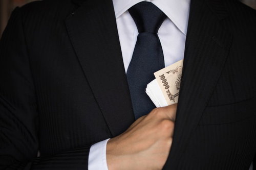 懐から紙幣をチラつかせるスーツの男