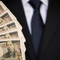 500万円の偽札をひけらかすスーツ姿の男性の写真
