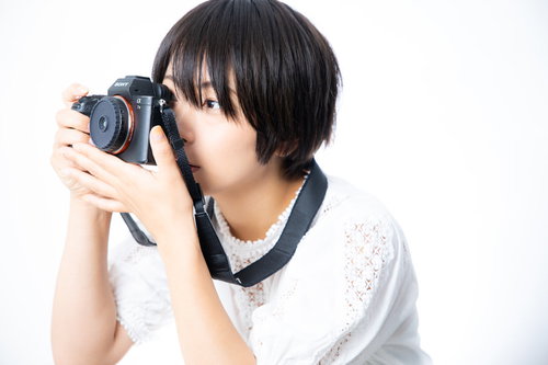 ファインダーを覗きながら構図を決める女子カメラマン