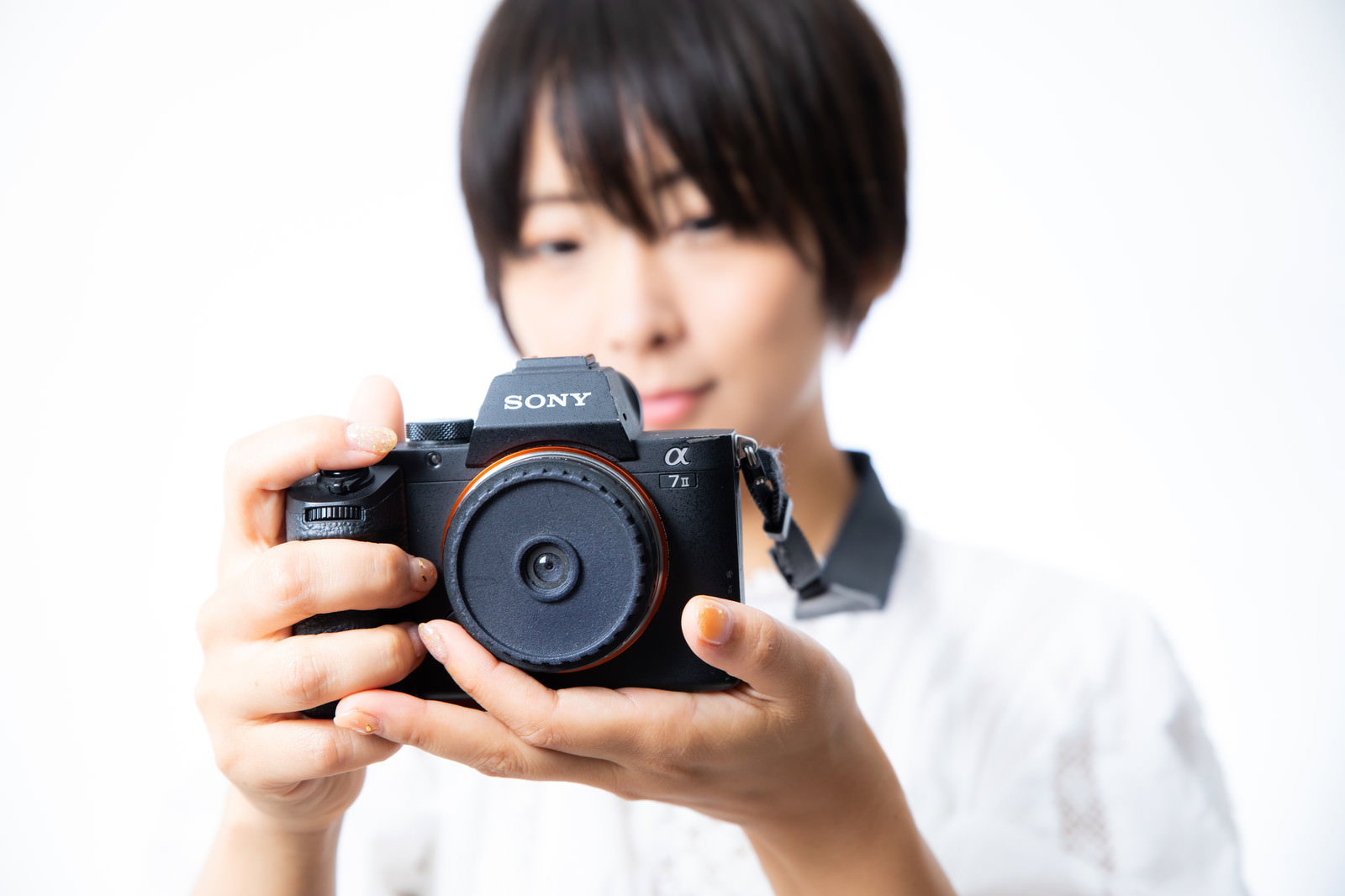 ミラーレスカメラを持つ女性フォトグラファー［モデル：にゃるる］