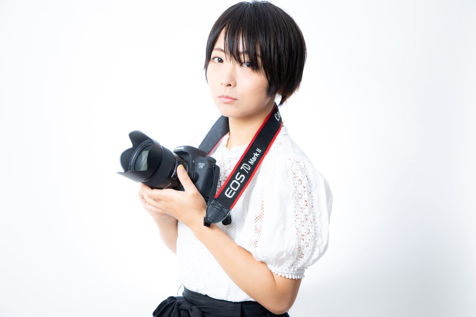 Canon 7D Mark2を両手で持つ白い衣装の女性カメラ女子［モデル：にゃるる］