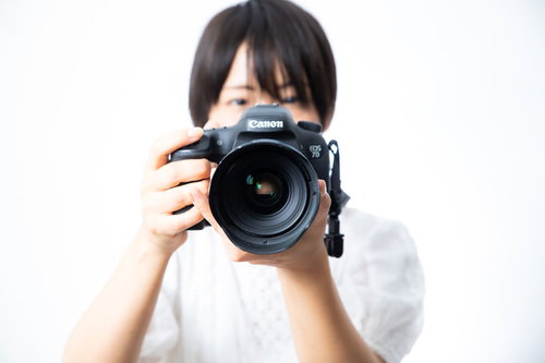 大口径のレンズで撮影中の女性フォトグラファー