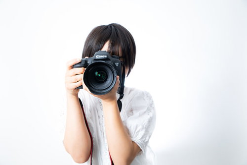 フォトグラファーのSNSアイコンにありがちな、一眼レフで撮影する女性の構図