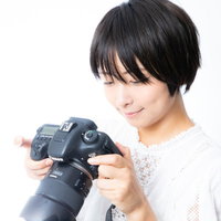 撮影した写真を液晶画面で確認するカメラ女子の写真