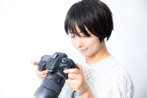 撮影した写真を液晶画面で確認するカメラ女子
