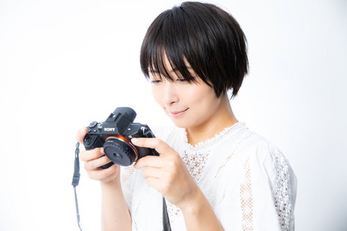 満足気な写真が撮れて笑みが溢れるカメラ女子のポートレート