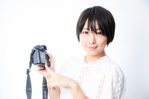 撮った写真をカメラの液晶で見せる嬉しそうなカメラ女子