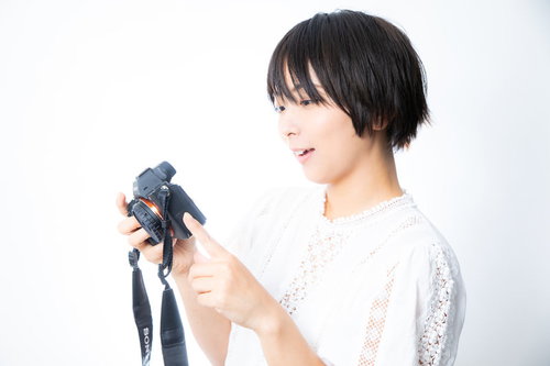 撮影したミラーレスカメラの写真を嬉しそうに眺めるカメラ女子