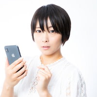 突然のメッセージでドキッとする女性のスマートフォン操作の写真