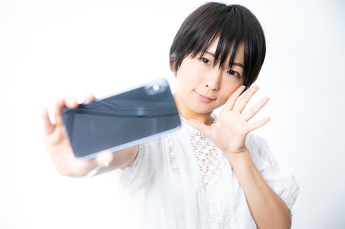 スマホで自撮り中の彼女がピースポーズを取る