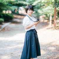 フォトウォーク中に振り返る公園でのカメラ女子の写真