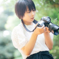 フォトウォーク女子がカメラを構える屋外撮影シーンの写真