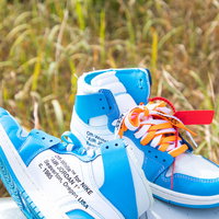 青白とオレンジ赤のおろしたてのハイカットスニーカーの写真