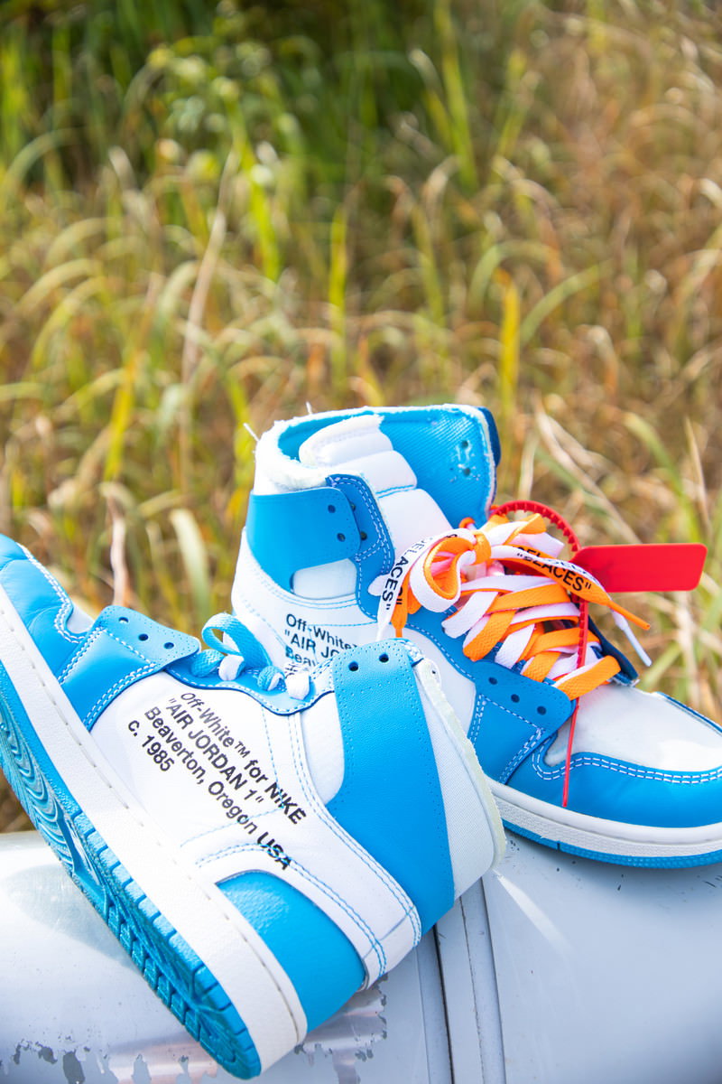 草の上に並べられた青白とオレンジ赤のハイカットスニーカー