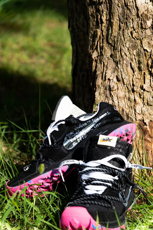 木の根元に飾られた白とピンクのNIKEエアズームテラカイガー
