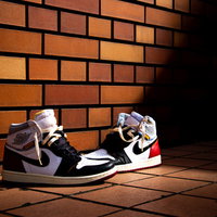 レンガ壁の前に置かれたAIR JORDANのスニーカーの写真