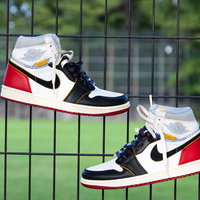 フェンスに吊るしたNIKEのエアジョーダン1スニーカーの写真