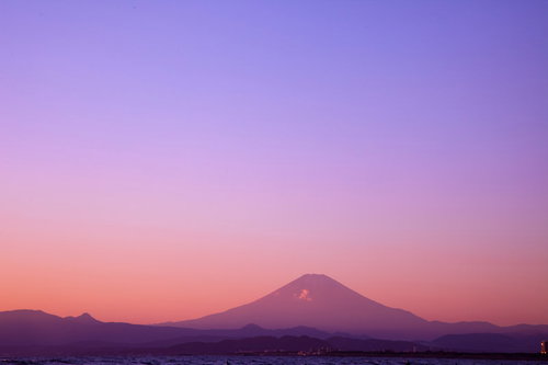 朝焼けに染まる富士山のシルエット、湖面に映る夜明けの風景
