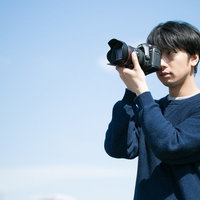 フルサイズ一眼レフを構えるカメラ男子の撮影風景の写真