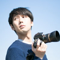 ロケーションに納得がいかず空を見上げるカメラマンの写真