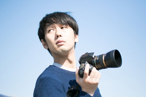 ロケーションに納得がいかず空を見上げるカメラマン