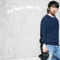 撮影チャンスを伺うカメラを手にした男性フォトグラファーの写真