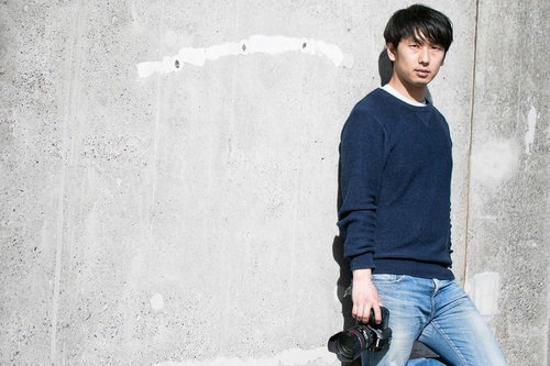 撮影チャンスを伺うカメラを手にした男性フォトグラファー
