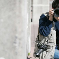 物陰に隠れて撮影する戦場カメラマンの写真