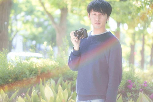 雨上がりの公園でフォトウォークをするカメラ男子