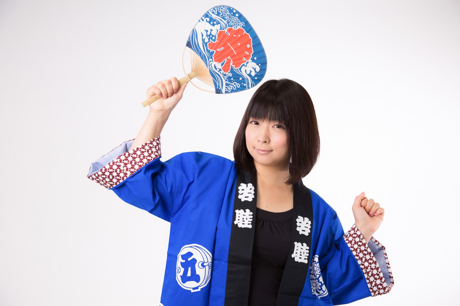 青い法被を着てうちわを掲げる笑顔の女性［モデル：にゃるる］