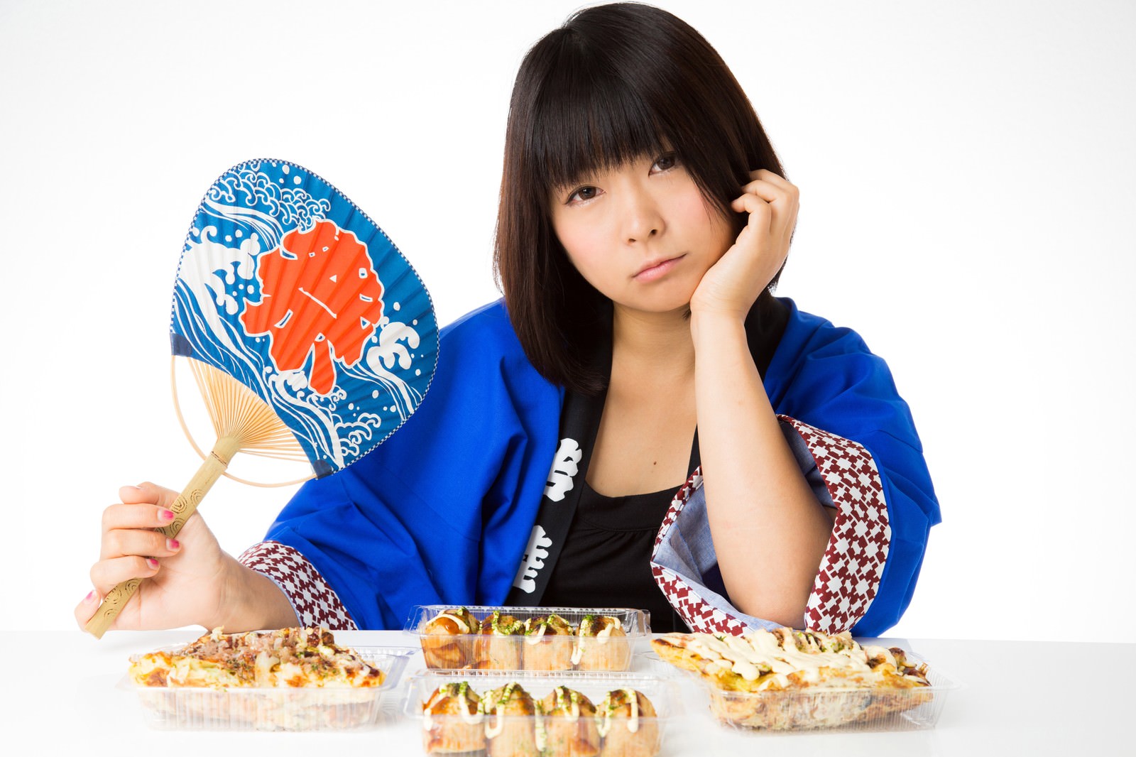 青い法被を着てたこ焼きの前で悩む女性［モデル：にゃるる］