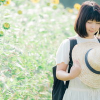 大好きなひまわり畑で麦わら帽を持つ女性、また来年も来れますように。の写真