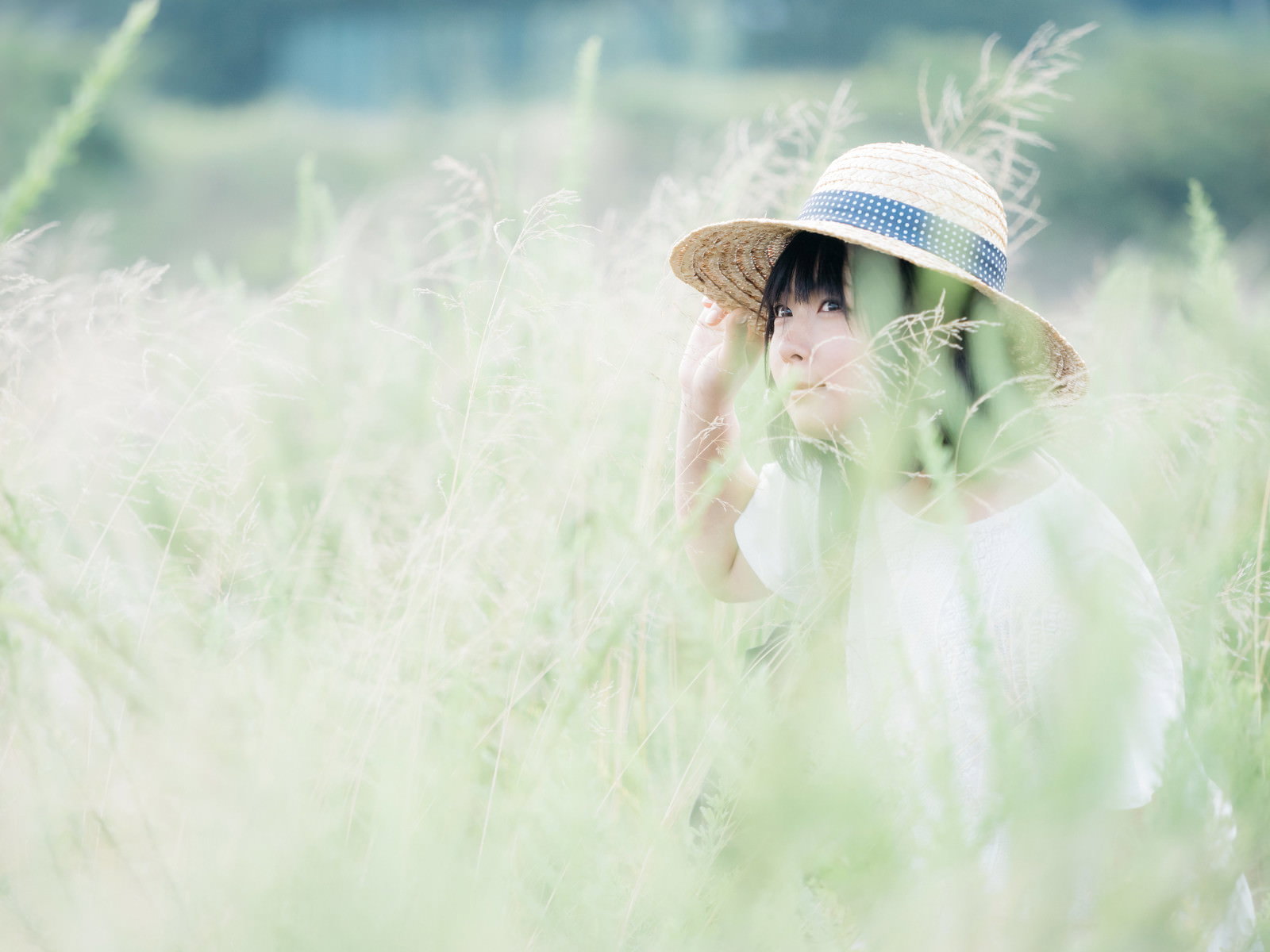 草原に隠れる麦わら帽の女性［モデル：にゃるる］