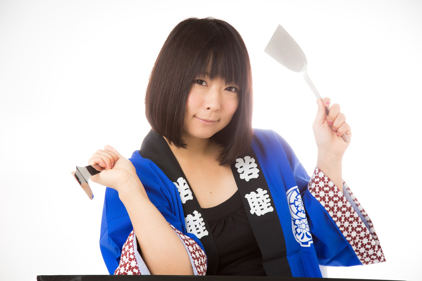 青い半被を着てヘラとコテを持つお好み焼き屋の女性［モデル：にゃるる］