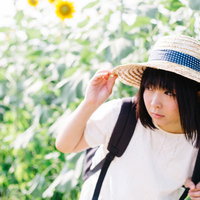 照りつける日差しが眩しいひまわり畑の麦わら帽女子の写真