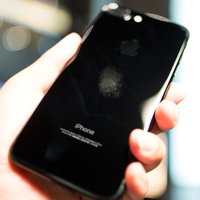 スマホのマップを確認しながら迷っている中間管理職の男性の写真