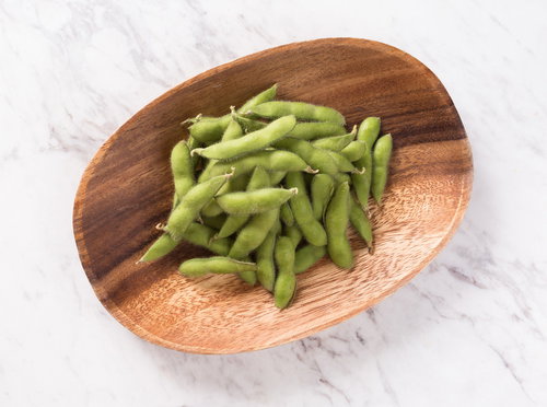 お通しの定番えだまめを木製プレートに盛り付け