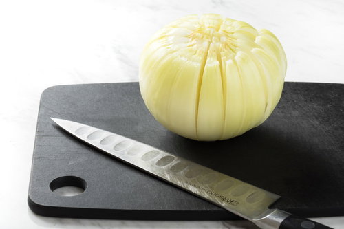 黒いまな板で16等分の切り込みが入った玉ねぎ