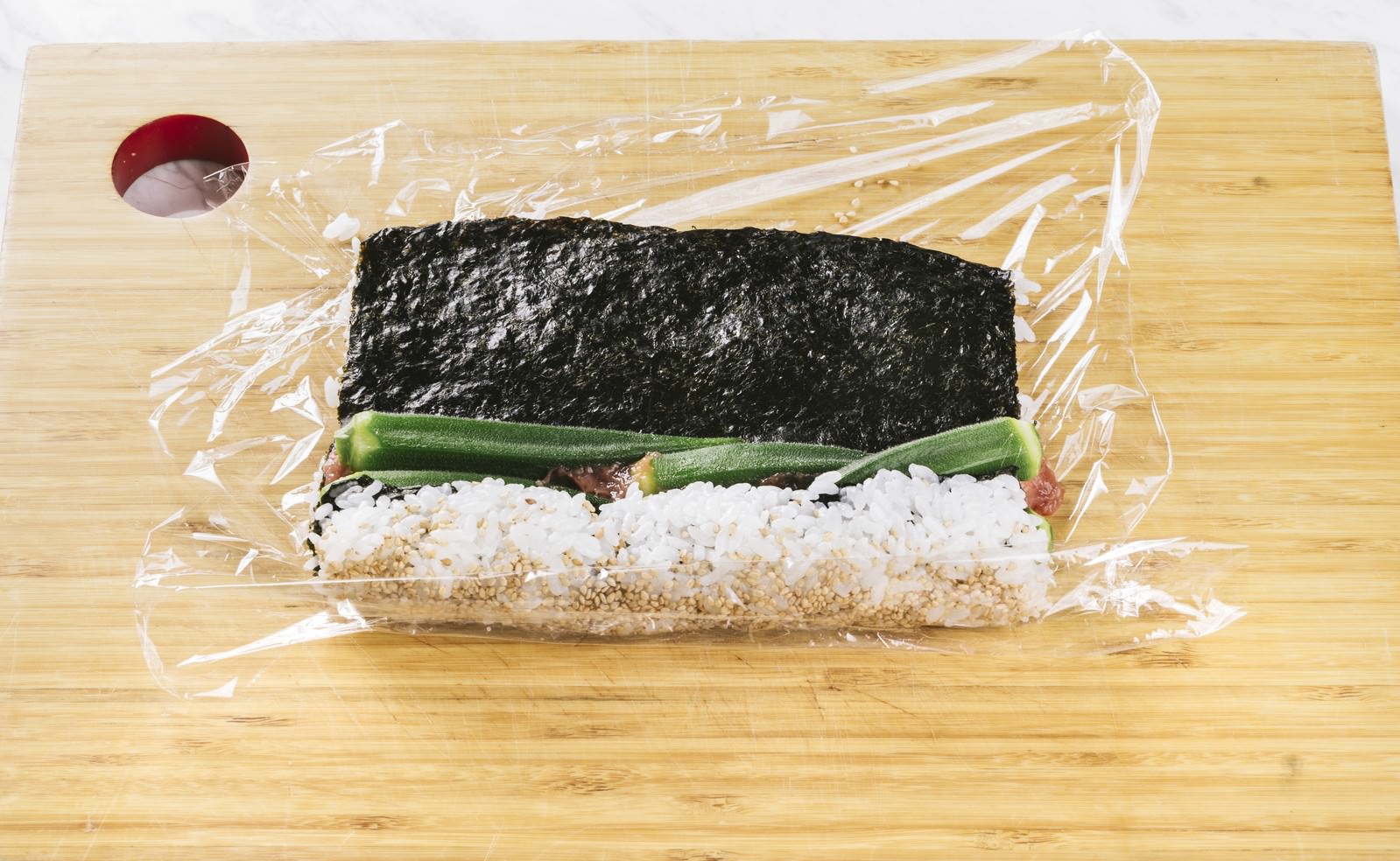 まな板の上でオクラの裏巻き寿司を作っている調理の様子