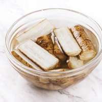 ごぼうを5cm幅に切ってガラスボウルの酢水にさらすの写真