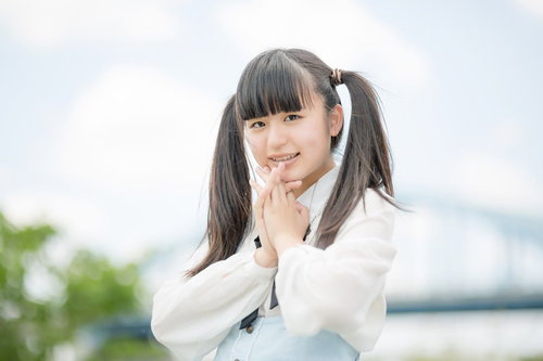 両手を顔に添えて笑うツインテールの女性