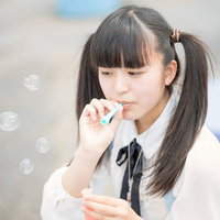 シャボン玉を吹くツインテールの女の子の写真