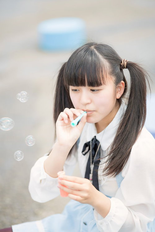 シャボン玉を吹くツインテールの女の子