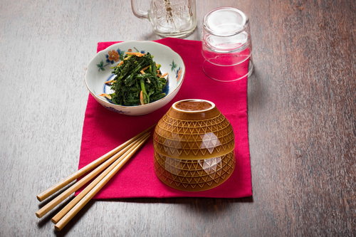 ご飯にもよく合う春菊のナムル、赤いランチョンマットに盛り付け